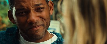 Movie still from “Hancock” (2008), directed by Peter Berg – A man's face with a necklace; Close Up shot, Over the shoulder angle