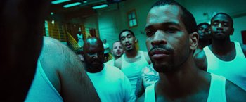 Movie still from “Hancock” (2008), directed by Peter Berg – A group of men standing next to each other in a room; Close Up shot, Over the shoulder angle