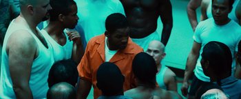 Movie still from “Hancock” (2008), directed by Peter Berg – A group of men standing next to each other in a room; Medium shot, Over the shoulder angle