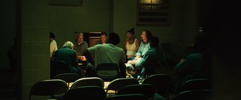 Movie still from “Hancock” (2008), directed by Peter Berg – A group of people sitting in a circle in a dark room; Wide shot, High angle