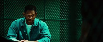 Movie still from “Hancock” (2008), directed by Peter Berg – A man sitting in front of a green wall; Medium shot, Over the shoulder angle