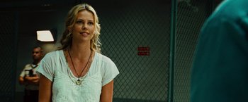 Movie still from “Hancock” (2008), directed by Peter Berg – A woman standing in front of a chain link fence; Close Up shot, Over the shoulder angle