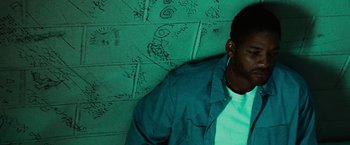 Movie still from “Hancock” (2008), directed by Peter Berg – A man sitting on the ground in front of a brick wall; Close Up shot, Overhead angle