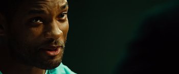 Movie still from “Hancock” (2008), directed by Peter Berg – A man's face in a green shirt; Close Up shot, Over the shoulder angle