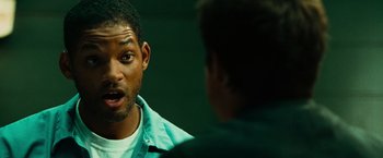 Movie still from “Hancock” (2008), directed by Peter Berg – A man talking to another man in front of a wall; Close Up shot, Over the shoulder angle