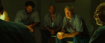 Movie still from “Hancock” (2008), directed by Peter Berg – A group of men sitting next to each other in a room; Medium shot, High angle