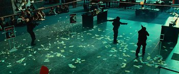 Movie still from “Hancock” (2008), directed by Peter Berg – A man standing in a room with papers on the floor; Wide shot, High angle
