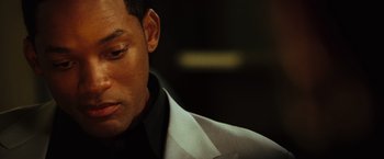 Movie still from “Hancock” (2008), directed by Peter Berg – A person wearing a suit and tie; Close Up shot, Over the shoulder angle