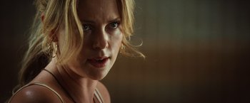 Movie still from “Hancock” (2008), directed by Peter Berg – A woman's face in a dark room; Close Up shot, Over the shoulder angle