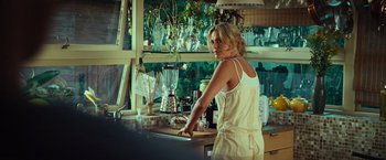 Movie still from “Hancock” (2008), directed by Peter Berg – A woman standing in a kitchen next to a blender; Medium shot, Over the shoulder angle
