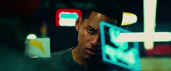 Movie still from “Hancock” (2008), directed by Peter Berg – A person with a neon sign in the background; Close Up shot, Over the shoulder angle