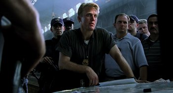 Movie still from “Hannibal” (2001), directed by Ridley Scott – A group of men standing next to each other in front of a table; Medium shot, Low angle