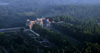 Movie still from “Hannibal” (2001), directed by Ridley Scott – An aerial view of an old castle in the middle of a forest; Extreme Wide shot, High angle