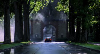 Movie still from “Hannibal” (2001), directed by Ridley Scott – A car driving down a street next to a building; Extreme Wide shot, Low angle