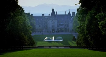 Movie still from “Hannibal” (2001), directed by Ridley Scott – A fountain in the middle of a lawn with a large building in the background; Extreme Wide shot, High angle