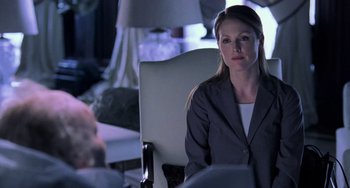Movie still from “Hannibal” (2001), directed by Ridley Scott – A woman sitting in front of a man in a suit; Medium shot, Over the shoulder angle