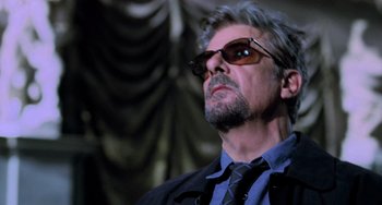 Movie still from “Hannibal” (2001), directed by Ridley Scott – A person wearing a suit and sunglasses; Close Up shot, Low angle