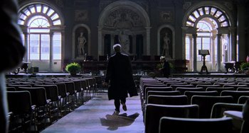 Movie still from “Hannibal” (2001), directed by Ridley Scott – A man in a black suit walking through a church; Wide shot, Low angle