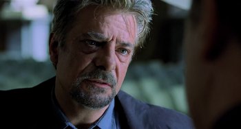Movie still from “Hannibal” (2001), directed by Ridley Scott – An older man with a beard and a mustache; Close Up shot, Over the shoulder angle
