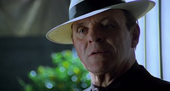 Movie still from “Hannibal” (2001), directed by Ridley Scott – An older man wearing a white hat and a black shirt; Close Up shot, Low angle