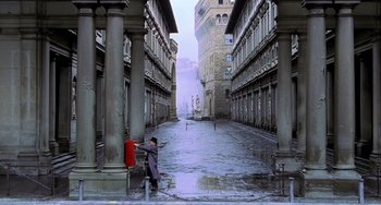 Movie still from “Hannibal” (2001), directed by Ridley Scott – A man standing on a street next to tall buildings; Extreme Wide shot, High angle