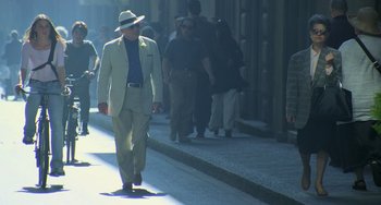 Movie still from “Hannibal” (2001), directed by Ridley Scott – An older man in a suit and hat walking down the street; Wide shot, Low angle