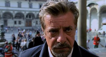 Movie still from “Hannibal” (2001), directed by Ridley Scott – A person wearing a suit and tie; Close Up shot, Over the shoulder angle