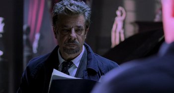 Movie still from “Hannibal” (2001), directed by Ridley Scott – A person wearing a suit and tie; Close Up shot, Over the shoulder angle