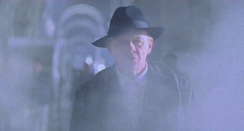 Movie still from “Hannibal” (2001), directed by Ridley Scott – A man wearing a hat and a suit; Close Up shot, Low angle
