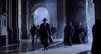 A group of people walking down a hall way