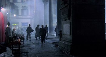 Movie still from “Hannibal” (2001), directed by Ridley Scott – A group of people walking down a street near a fire hydrant; Extreme Wide shot, Over the shoulder angle
