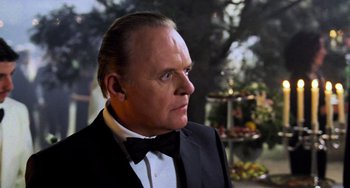 Movie still from “Hannibal” (2001), directed by Ridley Scott – An older man in a suit and bow tie looking to his left; Close Up shot, Over the shoulder angle