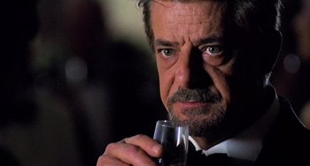 Movie still from “Hannibal” (2001), directed by Ridley Scott – A person holding a glass of wine; Close Up shot, Over the shoulder angle
