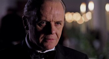 Movie still from “Hannibal” (2001), directed by Ridley Scott – A person wearing a suit and a bow tie; Close Up shot, Low angle