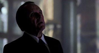 Movie still from “Hannibal” (2001), directed by Ridley Scott – A man in a suit and tie looking up; Close Up shot, Low angle