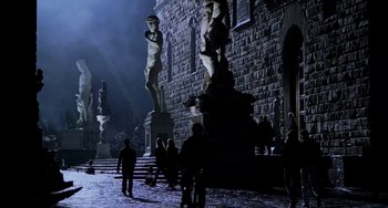 Movie still from “Hannibal” (2001), directed by Ridley Scott – A group of people standing next to a stone building; Extreme Wide shot, Low angle
