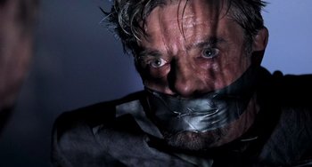 Movie still from “Hannibal” (2001), directed by Ridley Scott – A man with duct tape around his mouth; Close Up shot, Low angle