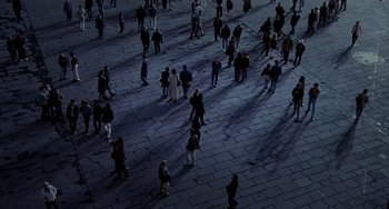 Movie still from “Hannibal” (2001), directed by Ridley Scott – A group of people standing on a sidewalk at night; Extreme Wide shot, Overhead angle