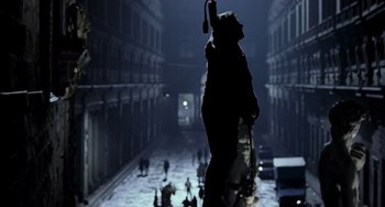 Movie still from “Hannibal” (2001), directed by Ridley Scott – A person holding an umbrella while standing in the middle of a street; Wide shot, Low angle