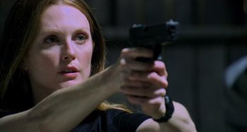 Movie still from “Hannibal” (2001), directed by Ridley Scott – A woman holding a gun in her hand; Close Up shot, Low angle