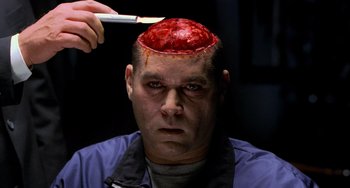 Movie still from “Hannibal” (2001), directed by Ridley Scott – A man is getting his head shaved with a brush; Close Up shot, Overhead angle