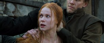Movie still from “Hansel & Gretel: Witch Hunters” (2013), directed by Tommy Wirkola – A woman with long red hair is getting her hair combed by a man; Close Up shot, Over the shoulder angle