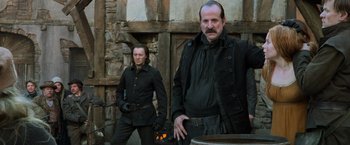 Movie still from “Hansel & Gretel: Witch Hunters” (2013), directed by Tommy Wirkola – Two men standing next to each other in front of a building; Medium shot, Low angle