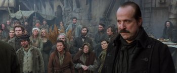 Movie still from “Hansel & Gretel: Witch Hunters” (2013), directed by Tommy Wirkola – A group of people standing in front of a stone wall; Medium shot, Low angle