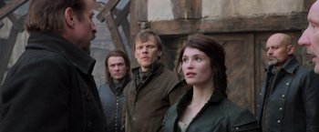Movie still from “Hansel & Gretel: Witch Hunters” (2013), directed by Tommy Wirkola – A group of people standing next to each other in front of a building; Medium shot, Over the shoulder angle