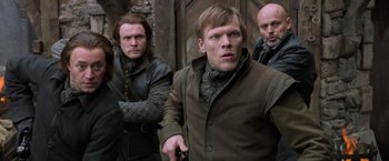 Movie still from “Hansel & Gretel: Witch Hunters” (2013), directed by Tommy Wirkola – A group of men standing next to each other; Medium shot, Low angle