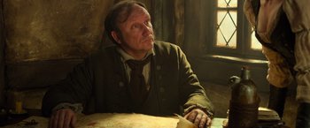 Movie still from “Hansel & Gretel: Witch Hunters” (2013), directed by Tommy Wirkola – A man sitting at a table in front of a window; Close Up shot, High angle