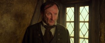 Movie still from “Hansel & Gretel: Witch Hunters” (2013), directed by Tommy Wirkola – A person wearing a suit and tie; Close Up shot, Over the shoulder angle