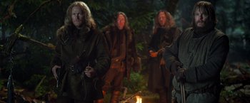 Movie still from “Hansel & Gretel: Witch Hunters” (2013), directed by Tommy Wirkola – A group of people standing around a fire; Medium shot, Over the shoulder angle