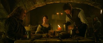 Movie still from “Hansel & Gretel: Witch Hunters” (2013), directed by Tommy Wirkola – A man and a woman sitting at a table with a lit candle; Medium shot, Low angle